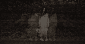 A ghostly girl in a white dress standing silently in a dark forest, holding a carved lantern, with eeire shadows fading besides her.